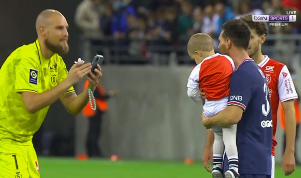 Thủ môn Predrag Rajkovic của Reims nhờ Messi bế và chụp ảnh cùng con mình